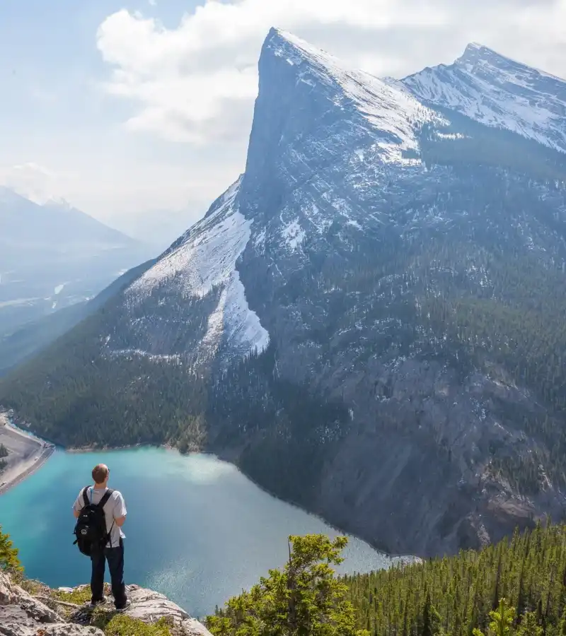 Hiker standing above a mountain lake